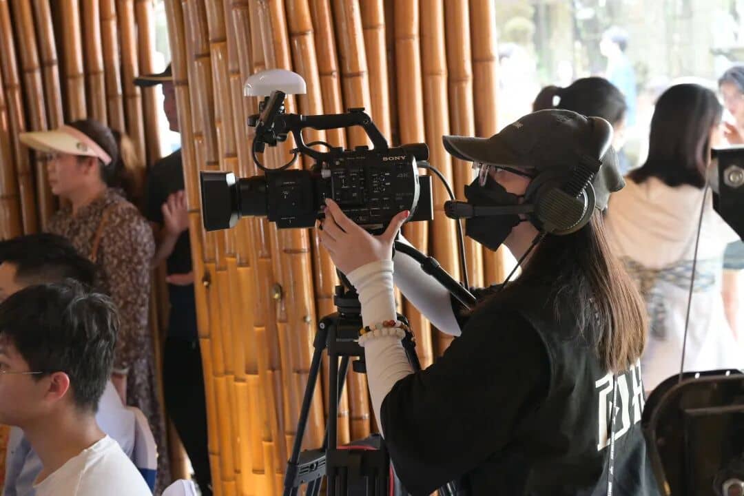 XinChuan Studio camera operator filming beside a bamboo setting