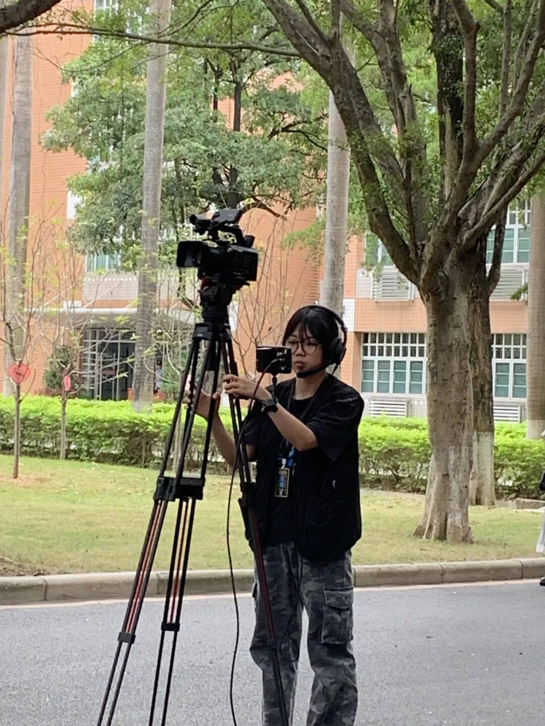 A XinChuan Studio member adjusting a tripod camera position in the food corridor area